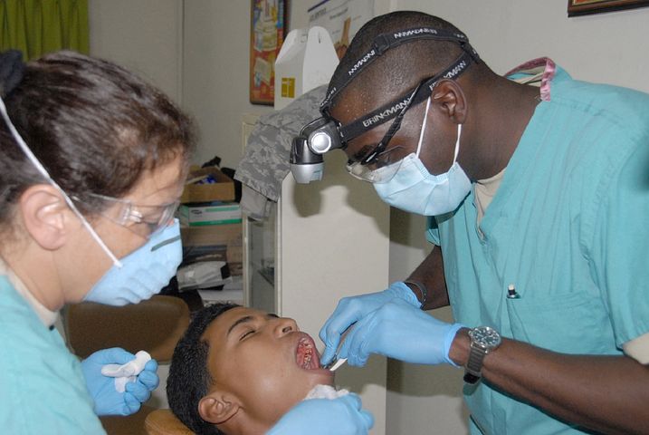 two dentists checking a patient's mouth