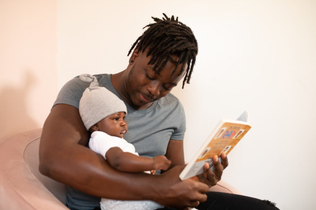 father reading a book to his child