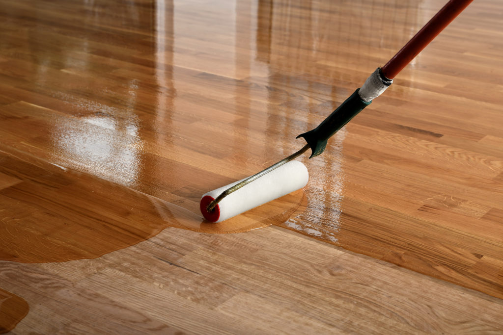hardwood flooring Melbourne worker lacquering the floor